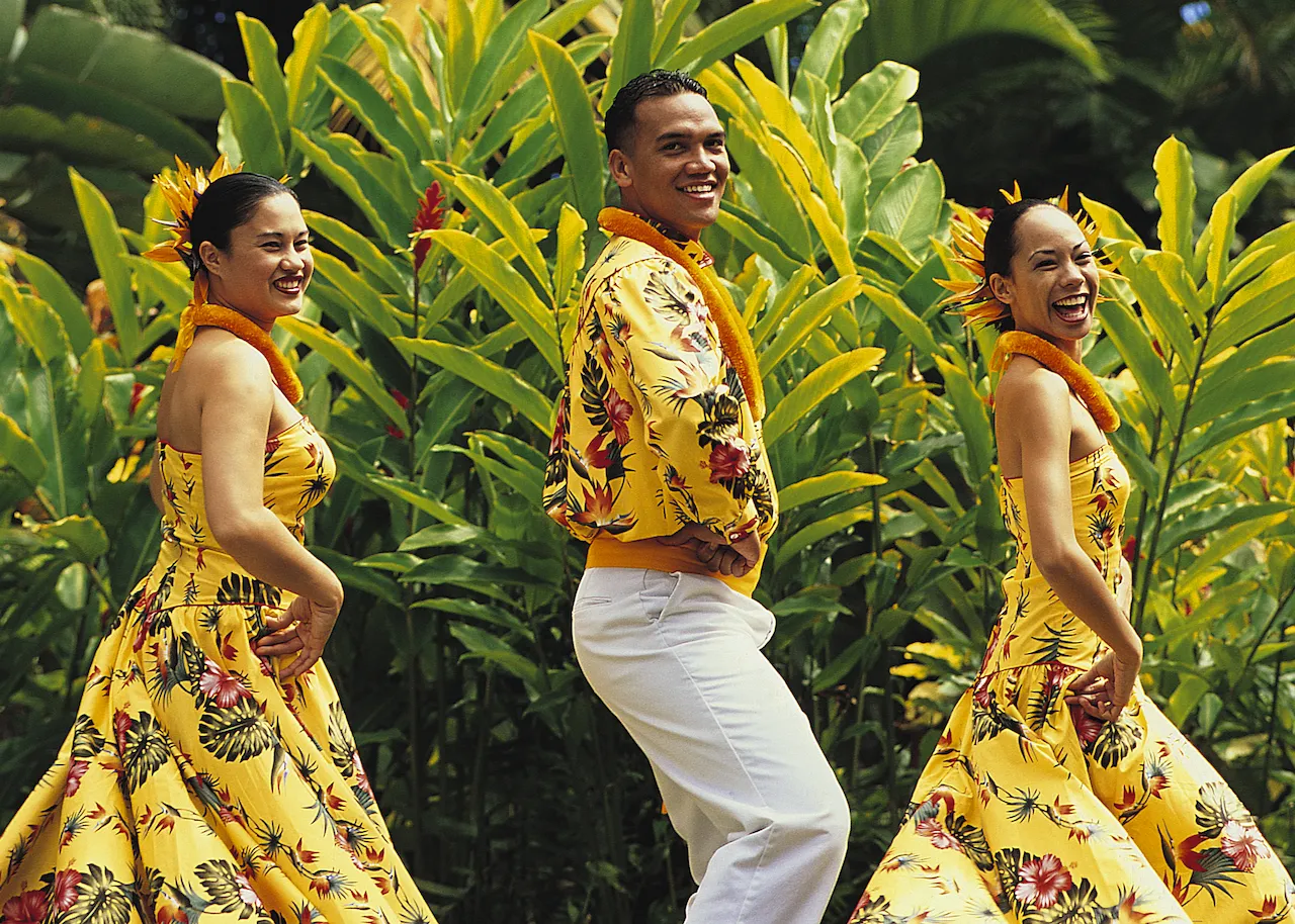 Three dancers in yellow Hawaiian costume.