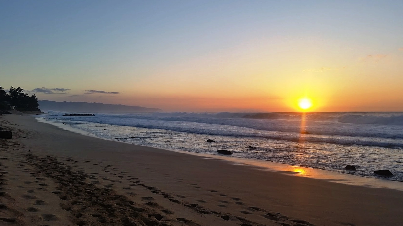 Brilliant sunset along a long stretch of sandy beach.