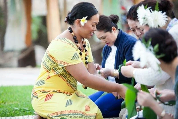 A woman kindly teaching how to weave with tī leaves.