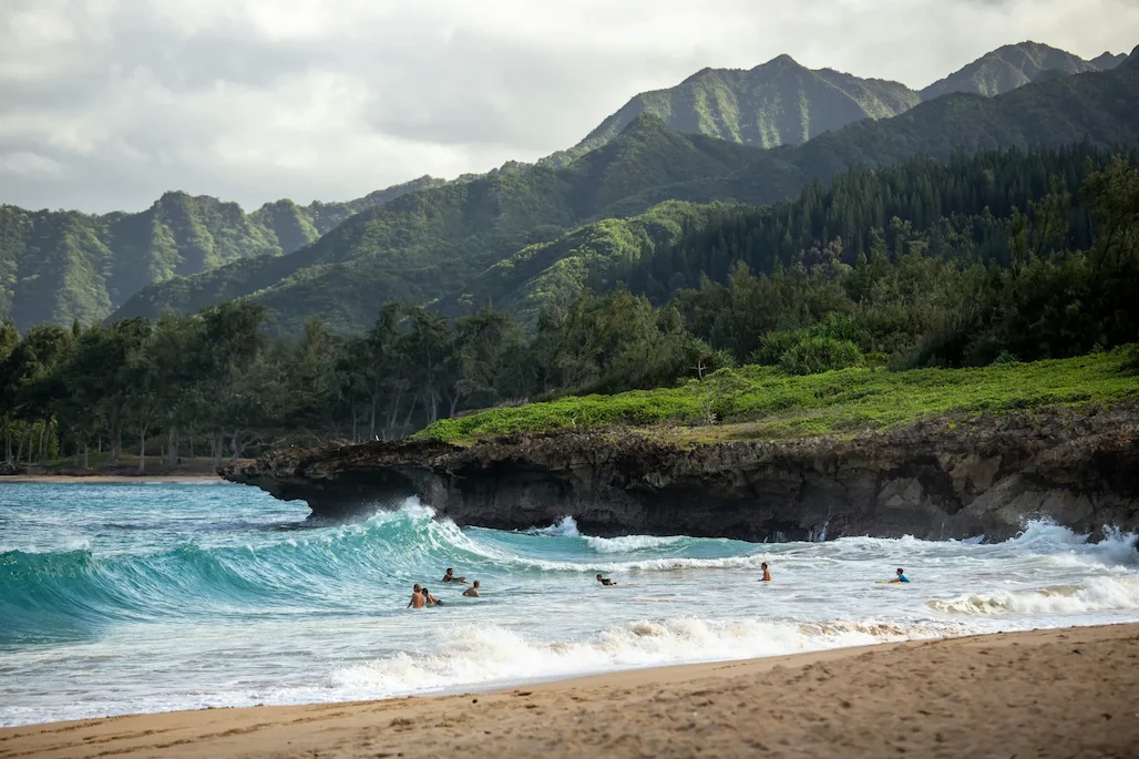 Beach-goers enjoying the large waves at Pounders Beach.