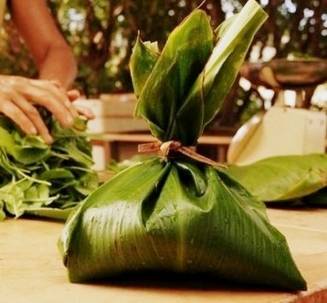 Palusami wrapped in large, green ti leaves and tied at the top