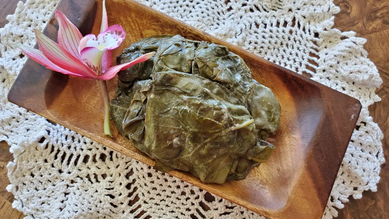 Palusami on a rectangle wooden plate.