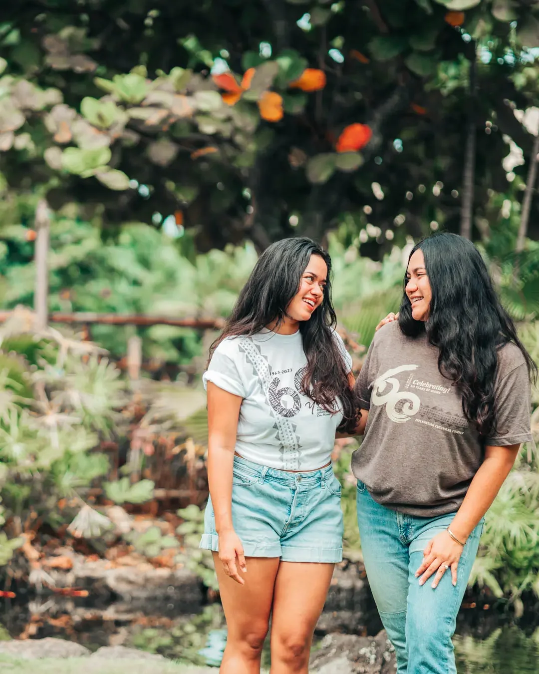 Two women posing for a photo in front the picturesque greenery by Hale ʻOhana.