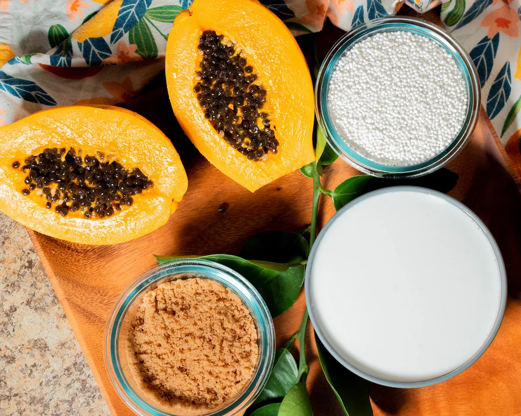 The five basic ingredients that you need to make supoesi: ripe papaya, tapioca pearls, sugar, coconut milk, water, and lemon leaves for natural fragrance.